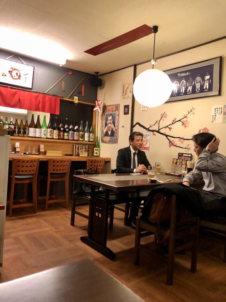 locals having sake at an izakaya bar